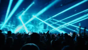 Foto van festival met dansende mensen op hardcoremuziek, er schijnen blauwe lampen de zaal in.