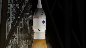 Foto van NASA-raket op lanceerplatform, grote witte raket waarop met rode letters NASA staat.