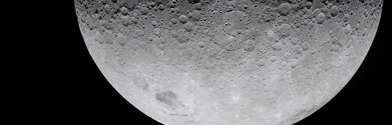 Foto van de onderste helft van de maan, grijs oppervlak met kraters met daarachter zwarte leegte.