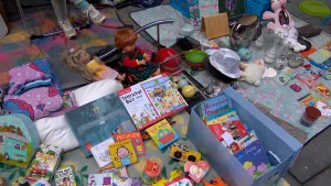 Foto van een kleedje op de vrijmarkt waarop speelgoed, boeken en knuffels worden aangeboden.