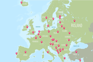 Een getekende kaart van Europa. De landen zijn groen gekleurd, de zeeën en oceanen blauw. De namen staan in tekst op de landen geschreven en bij elke hoofdstad staat een rode marker.