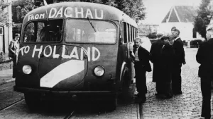 Zwart-wit foto van een bus waarop staat 'from Dachau to Holland'.