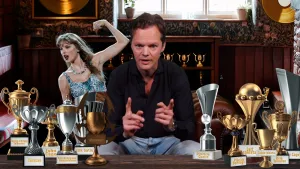 Foto van presentator Sander Zwiep met allerlei bekers en trofeeen en een foto van zangeres Taylor Swift.