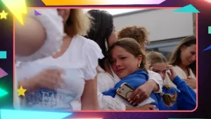 Foto van meisjes die elkaar omhelzen bij en afscheid, meisje kijkt erg verdrietig.