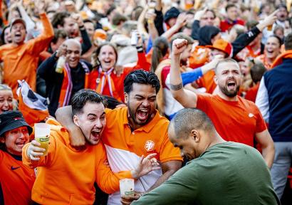 Foto van juichende oranjefans tijdens een wedstrijd van het Nederlands elftal.