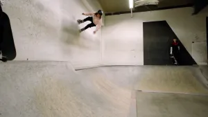 Foto van presentator Pascal met zijn skates op een schuine wand in een skatepark.