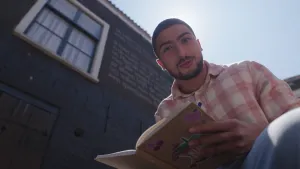 Presentator Nizar heeft een boek in zijn handen.