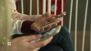Een foto van drie paar handen op een rij, de handen houden drie telefoons vast. Het zijn de handen van drie leerlingen die naast elkaar op hun telefoon zitten te kijken.