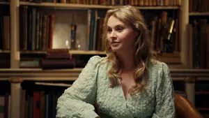 Foto van musicalactrice Vajen van den Bosch voor oude boekenkast.