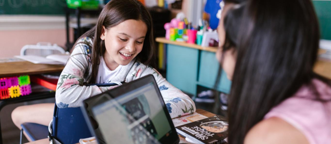 schoolklas met 2 meisjes met een laptop