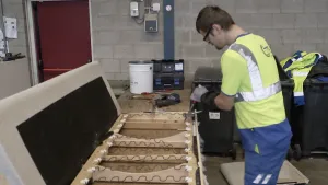 Foto van een persoon die een oude bank uit elkaar schroeft.