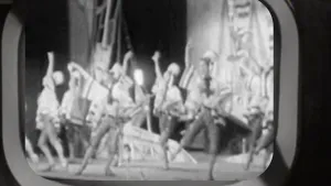 zwart-wit fot van oude tv met daarop beelden van danseressen.