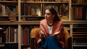 Foto van klimaatactiviste Hannah Prins voor een oude boekenkast.
